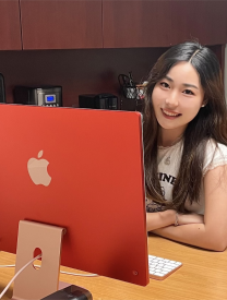 Young woman sitting at red computer